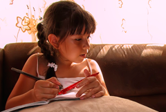 niña haciendo ejercicios en de inglés en el sofá